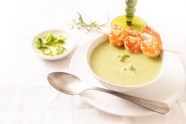 king prawns with green vegetable cream soup on a white tablecloth, copy space, selected focus, narrow depth of field - Foto, Imagen