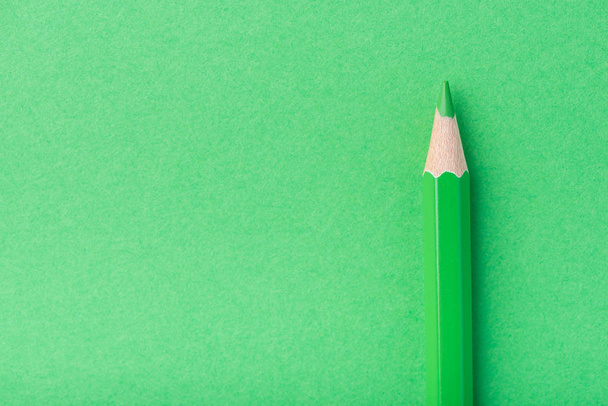 Makrofotografie mehrerer zugespitzter Bleistifte grüner Farbe auf einem Papierhintergrund - Foto, Bild