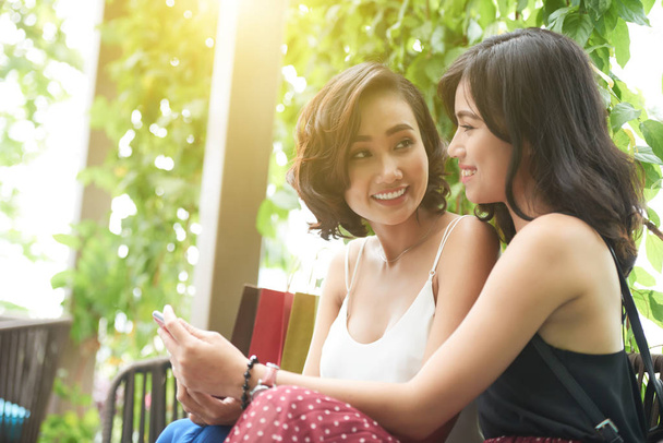 Cheerful attractive young Asian women with smartphone - Photo, image