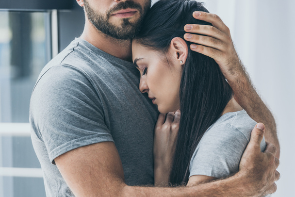 Oříznout záběr vousatý muž objímání a podpoře mladých smutná žena - Fotografie, Obrázek