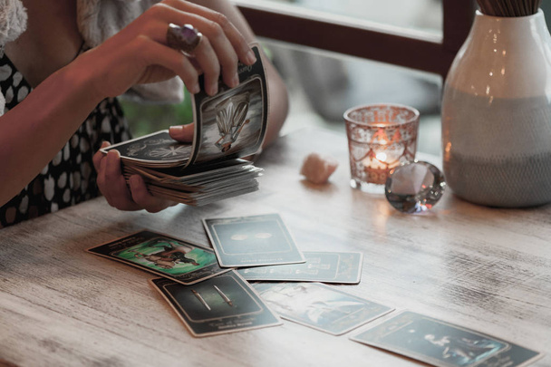 Woman is reading Tarot cards on the table in cafe - Foto, Imagem