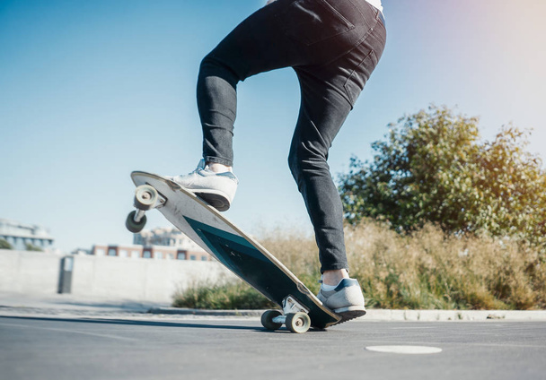 Young attractive man riding and jumping longboard in the park. - Foto, immagini