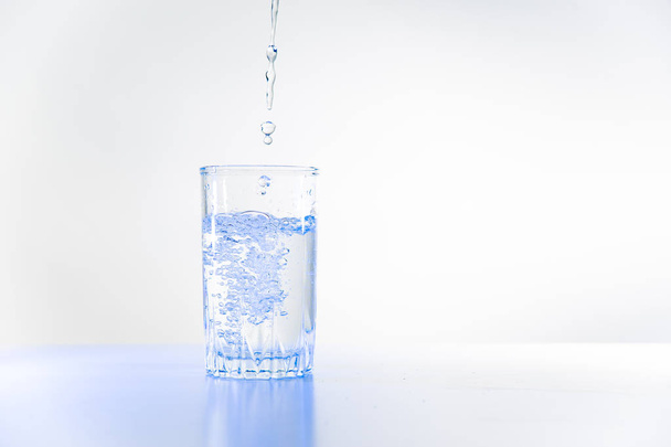 Glass of pure water on a white kitchen table - Foto, immagini