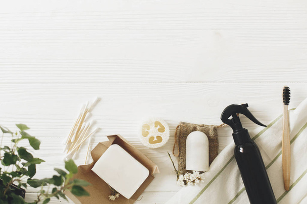 zero waste concept, sustainable lifestyle flat lay. natural eco bamboo toothbrush, coconut soap, handmade detergent, crystal deodorant, luffa, bamboo ear sticks, green leaves - 写真・画像