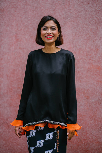 Portrait of a young, attractive and photogenic Singaporean Malay woman posing outdoors  - 写真・画像