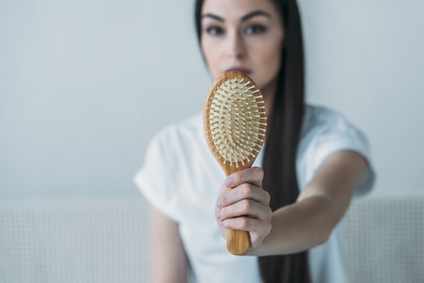 vista de cerca de la joven mujer sosteniendo cepillo de pelo con el pelo caído en gris
  - Foto, Imagen