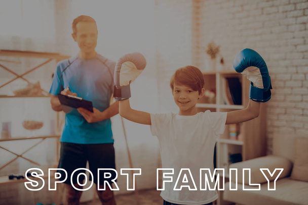 Smiling Father And A Son Are Noting Physical Results. Sports Family. Healthy Lifestyle. Active Holiday. Gym Clothes. Information Tablet. Getting Better. Working Out At Home. Kid With Boxing Gloves. - 写真・画像
