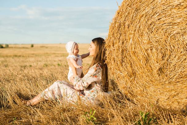 Mom and daughter in a field with stacks - Foto, Bild