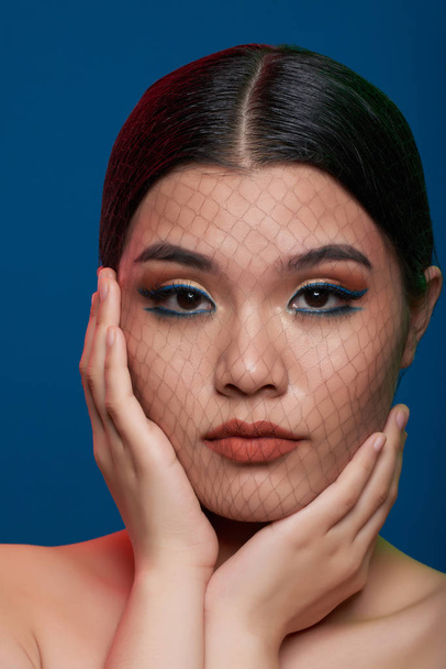 Portrait of attrative young woman with make-up and fishnet on her face - Foto, Imagem