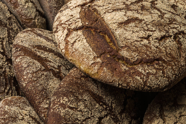 Fırın ekmek üreticileri - altın rustik huysuz somun ekmek ve siyah kara tahta zemin üzerine buns. Natürmort (üstten görünüm yukarıda, düz yatıyordu yakalanan). - Fotoğraf, Görsel
