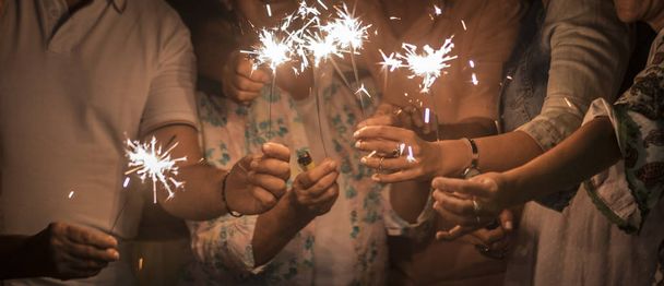 οικογένεια με φωτιά σπινθήρες γιορτάζει και να διασκεδάζουν κατά τη διάρκεια της νύχτας - Φωτογραφία, εικόνα