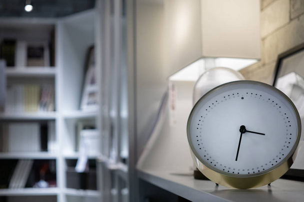 Modern white clock in the living room with book shelves and lamp - Photo, Image