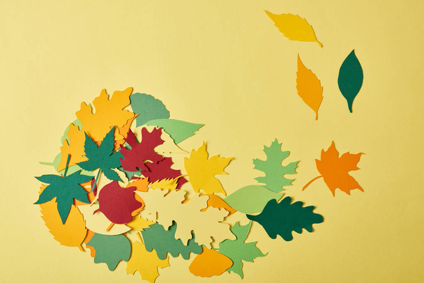 flat lay with colorful papercrafted foliage arranged on yellow background - Photo, Image