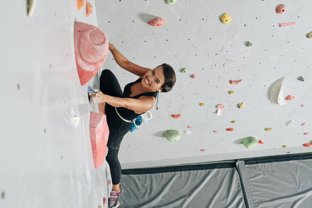 asian woman in sportswear climbing wall  - Photo, Image