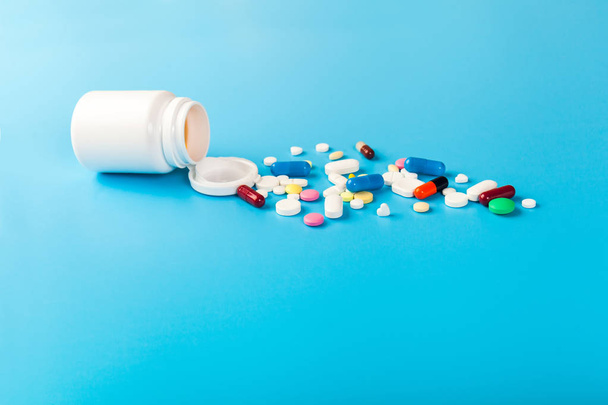 Medicines, supplements and drugs in a bottle on blue background - 写真・画像