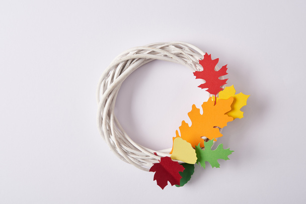 top view of handmade wreath with colorful paper foliage on white backdrop - Fotografie, Obrázek