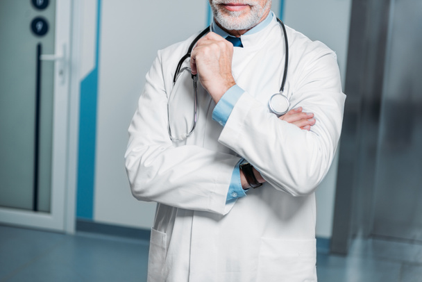 Μερική άποψη του αρσενικό ο γιατρός με το στηθοσκόπιο πάνω από το λαιμό στο νοσοκομείο - Φωτογραφία, εικόνα