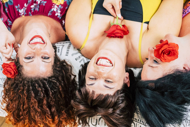 自宅のベッドの上に敷設する若い女性の遊び心のあるグループは一緒に笑いと笑顔 - 写真・画像