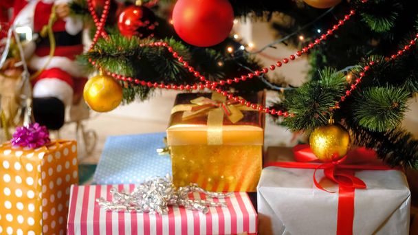 Pila de regalos de Santa y regalos que yacen bajo el árbol de Navidad en la sala de estar
 - Foto, imagen