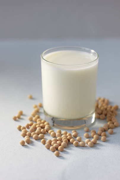 Soybean milk with soy beans around it. - Foto, afbeelding