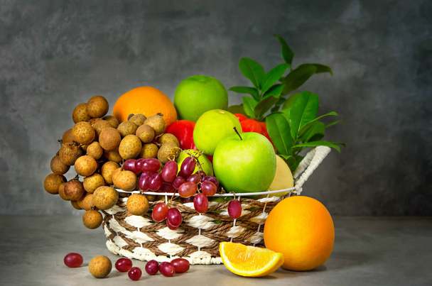 fresh vegetables and fruits in wicker basket over wooden background - Photo, Image