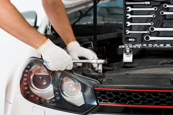 image recadrée de mécanicien automobile auto réparation de voiture avec clé sur blanc
 - Photo, image