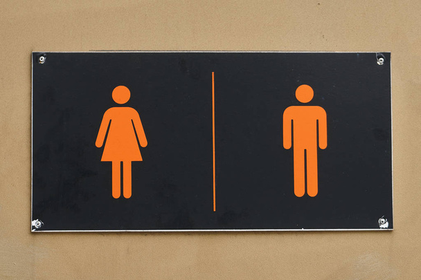 schwarzes Schild mit Silhouetten von Mann und Frau an der Toilettentür - Foto, Bild
