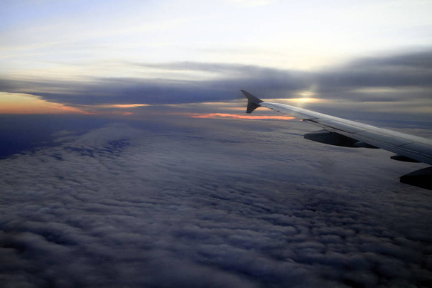 Puesta de sol a gran altura sobre las nubes desde una ventana plana
 - Foto, imagen