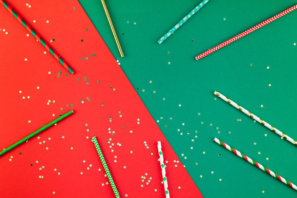 新年やクリスマス パターン フラット トップ ビュー クリスマス休日のお祝いカクテルパーティ ストロー赤グリーン ペーパー金いろ背景を飲むが横たわっていた。グリーティング カードのテンプレート 2019年テキスト デザインします。 - 写真・画像