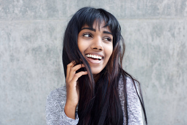 Εσωτερικη πορτρέτο των νέων ινδική γυναίκα γελάει με το χέρι στα μαλλιά - Φωτογραφία, εικόνα
