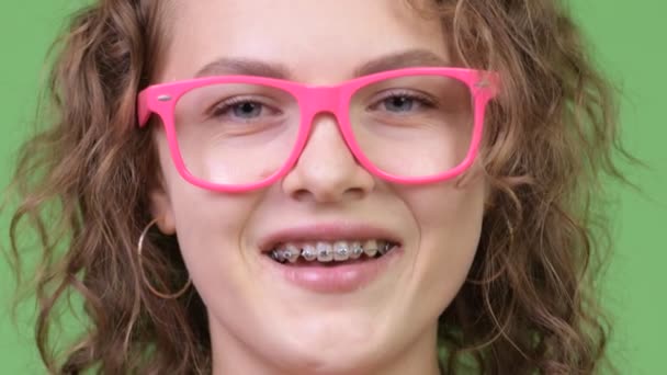 Νέοι ευτυχής όμορφη nerd γυναίκα φοράει γυαλιά ενώ χαμογελώντας με τιράντες - Πλάνα, βίντεο