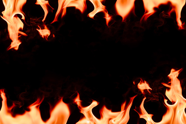 close up view of burning orange flame with blank space in middle on black background - Photo, Image