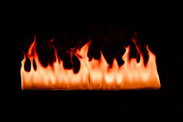 close up view of burning orange fire on black background - Foto, afbeelding