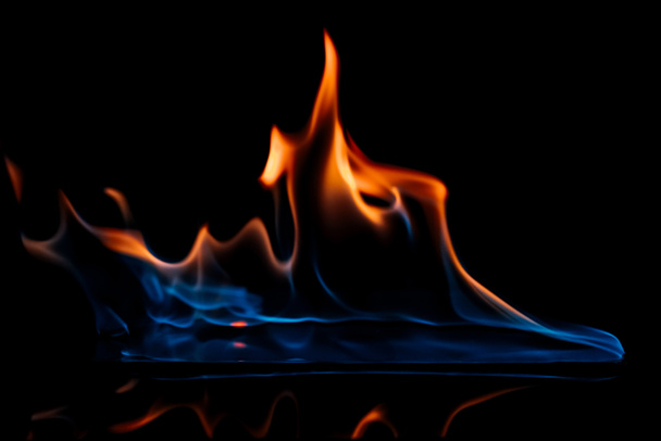 vue rapprochée de la flamme orange et bleue brûlante sur fond noir
 - Photo, image