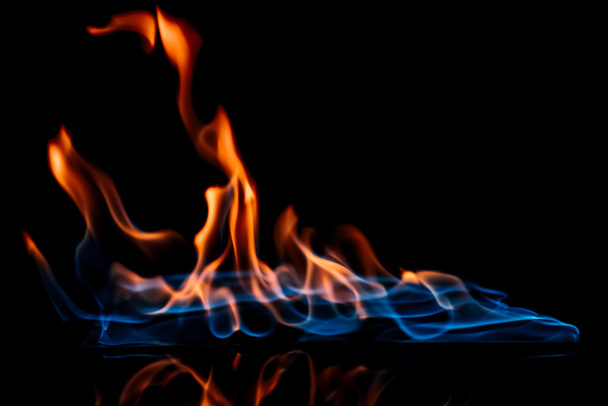 вид горящего оранжевого и синего пламени на чёрном фоне
 - Фото, изображение