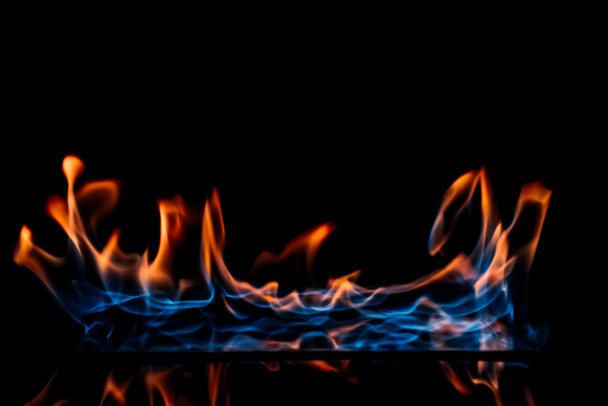 close up view of burning orange and blue flame on black background - Photo, Image