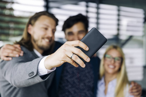 Muotokuva hymyilevät liikemiehet poseeraa selfie
 - Valokuva, kuva