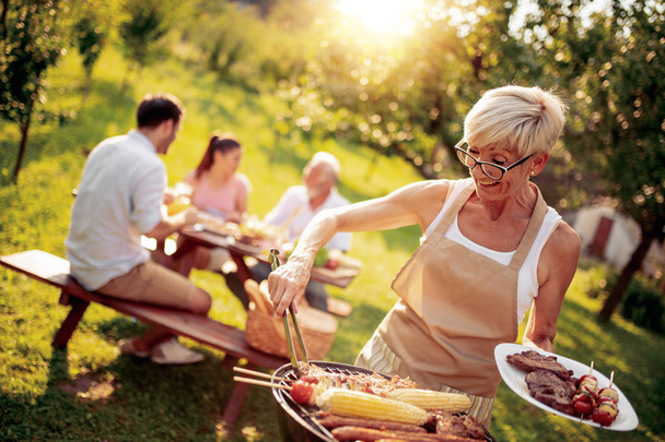 Family having a barbecue party in their garden in summer. - Photo, Image