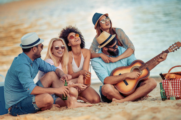 Веселые друзья наслаждаются выходными и веселятся на пляже
. - Фото, изображение