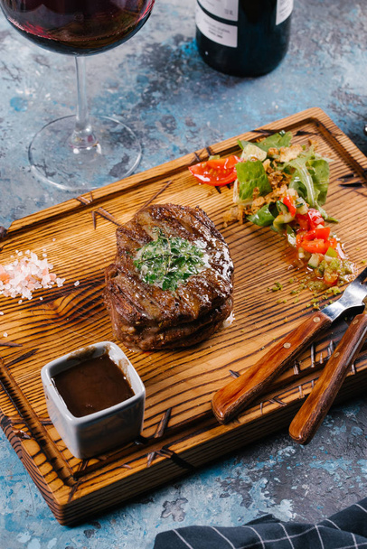 Fresh medium raw steak served with vegetable salad on wooden chopping board - Foto, Bild