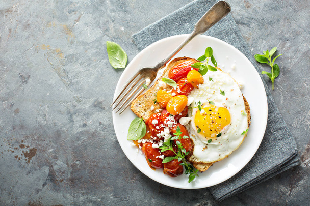 Multigrain toast with fried egg and roasted tomatoes - Фото, изображение