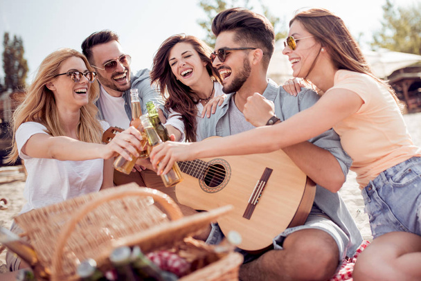 Skupina happy mladých lidí na pikniku na pláži. Léto, prázdniny, dovolená, hudbu a lidé koncepce. - Fotografie, Obrázek
