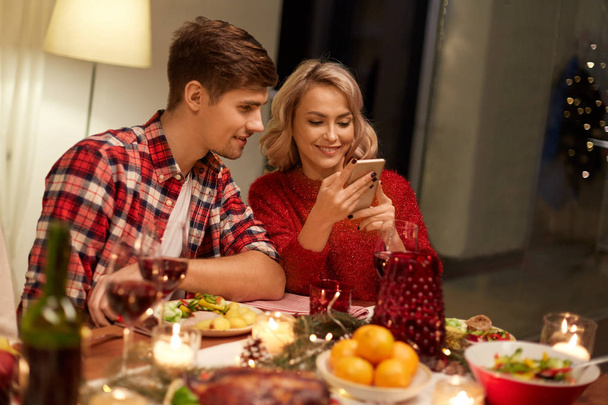 couple with smartphone at home christmas dinner - Foto, Bild