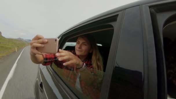 Mladá dívka dělá selfie z okna auta - Záběry, video