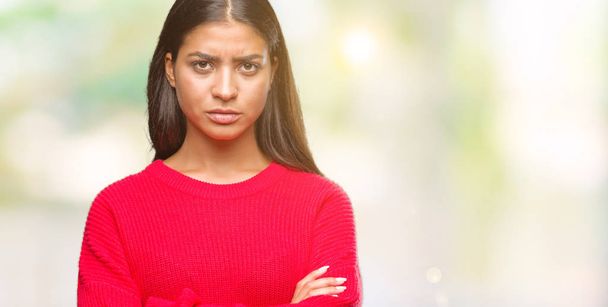 Young beautiful arab woman wearing winter sweater over isolated background skeptic and nervous, disapproving expression on face with crossed arms. Negative person. - Photo, Image