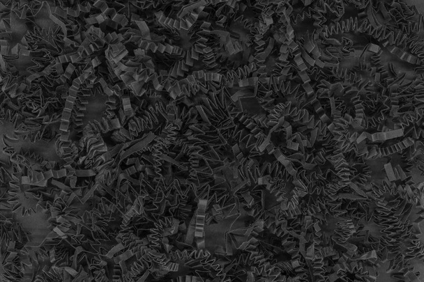 Ramo de tiras de papel de cartón rizado negro trituradora de fondo colocado en la superficie de fondo negro
 - Foto, Imagen