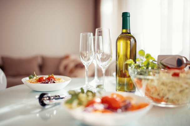 Φρέσκια σαλάτα και κρασί στο τραπέζι, στενή-up. - Φωτογραφία, εικόνα