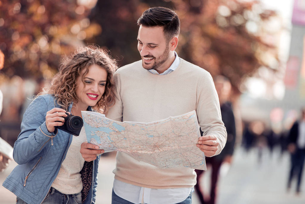Couple of tourist traveling and using map.Couple of tourist exploring a city. - Photo, Image