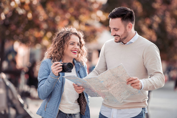 Couple of tourist traveling and using map.Couple of tourist exploring a city. - Foto, Bild