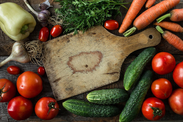 frische Zutaten zum Kochen in rustikaler Umgebung, Tomaten, Karotten und Gurken. natürliches, gesundes Bio-Ernährungskonzept. Ansicht von oben - Foto, Bild